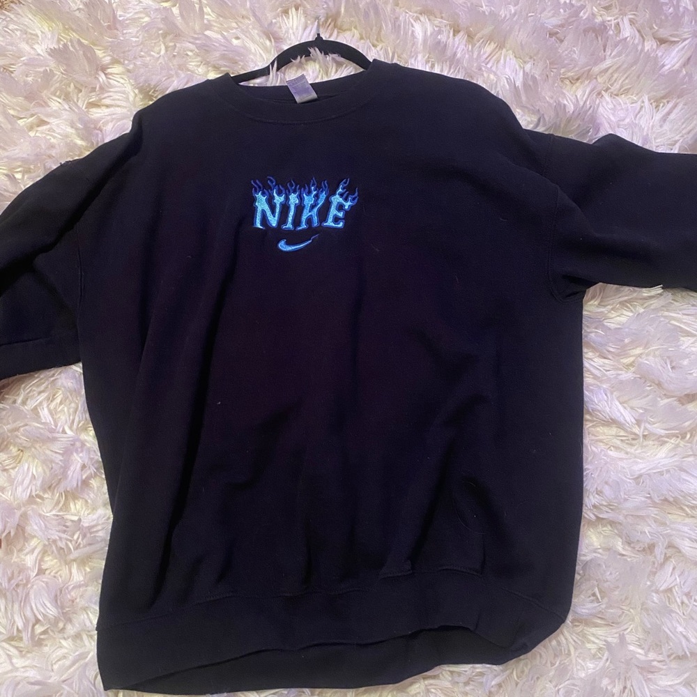Black hoodie with blue Nike flames coming out of it.